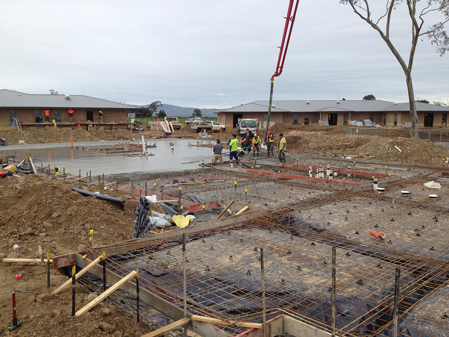 A crane pouring concrete for a slab foundation